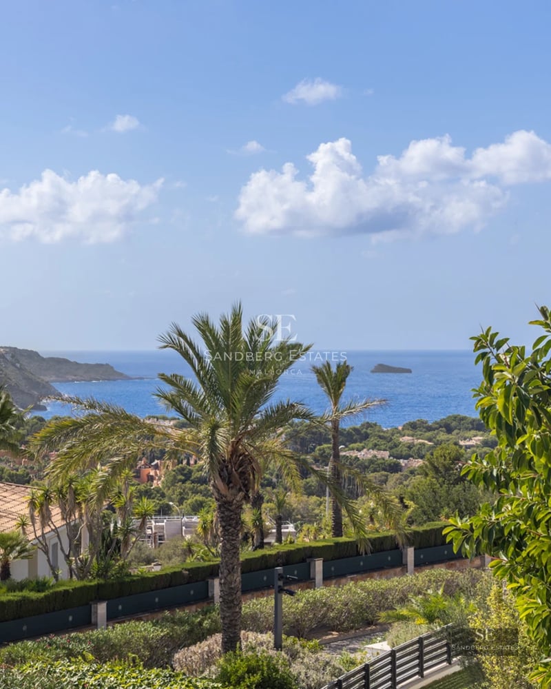 Spacious living room featuring picture windows, light wood flooring, modern fireplace, and designer furniture in neutral tones.