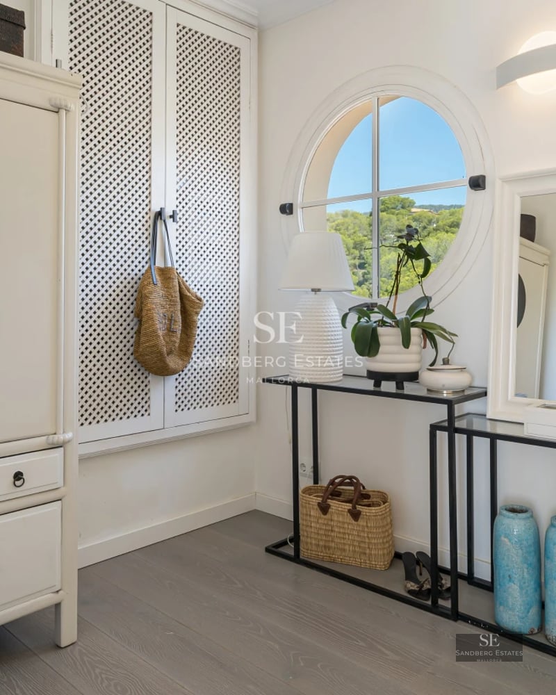 Spacious living room featuring floor-to-ceiling windows, modern fireplace, beige sofas, light rug and panoramic views. Minimalist and elegant design.