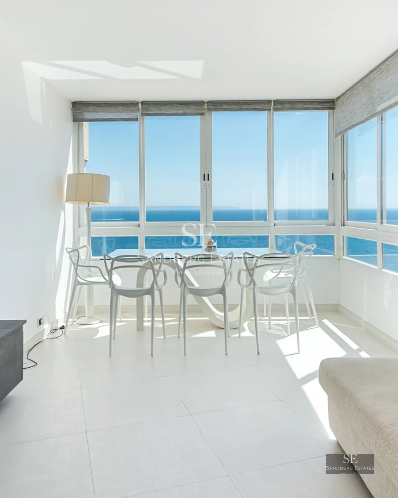Spacious living room with balcony and sea view. Modern furniture, natural lighting, and neutral color palette. Elegant architecture.
