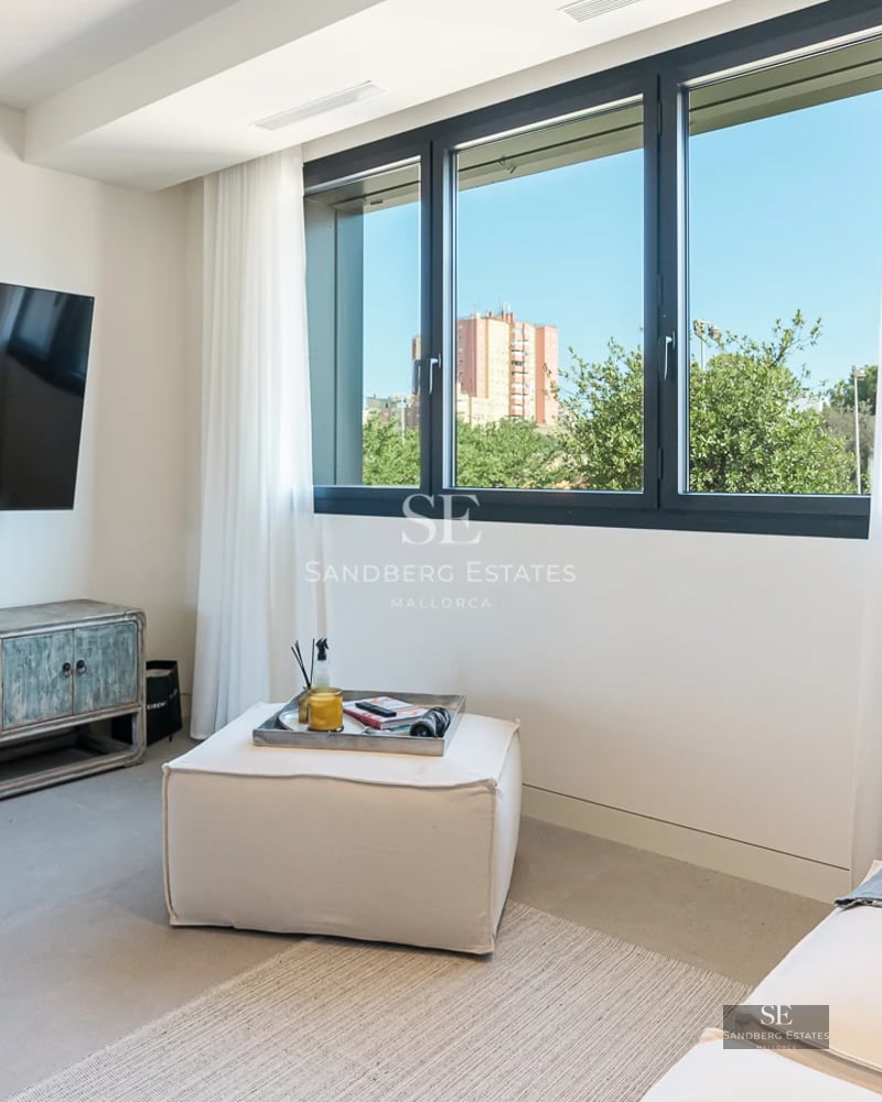 Bright living room with sea view. Large windows, modern design, glazed balcony. Elegant and minimalist interior.