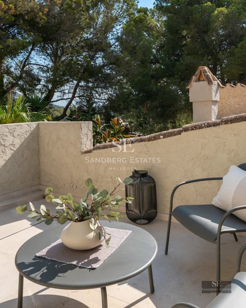 Spacious, bright living room with outdoor pool visible through large windows. Modern design, wooden floors, and minimalist furniture.