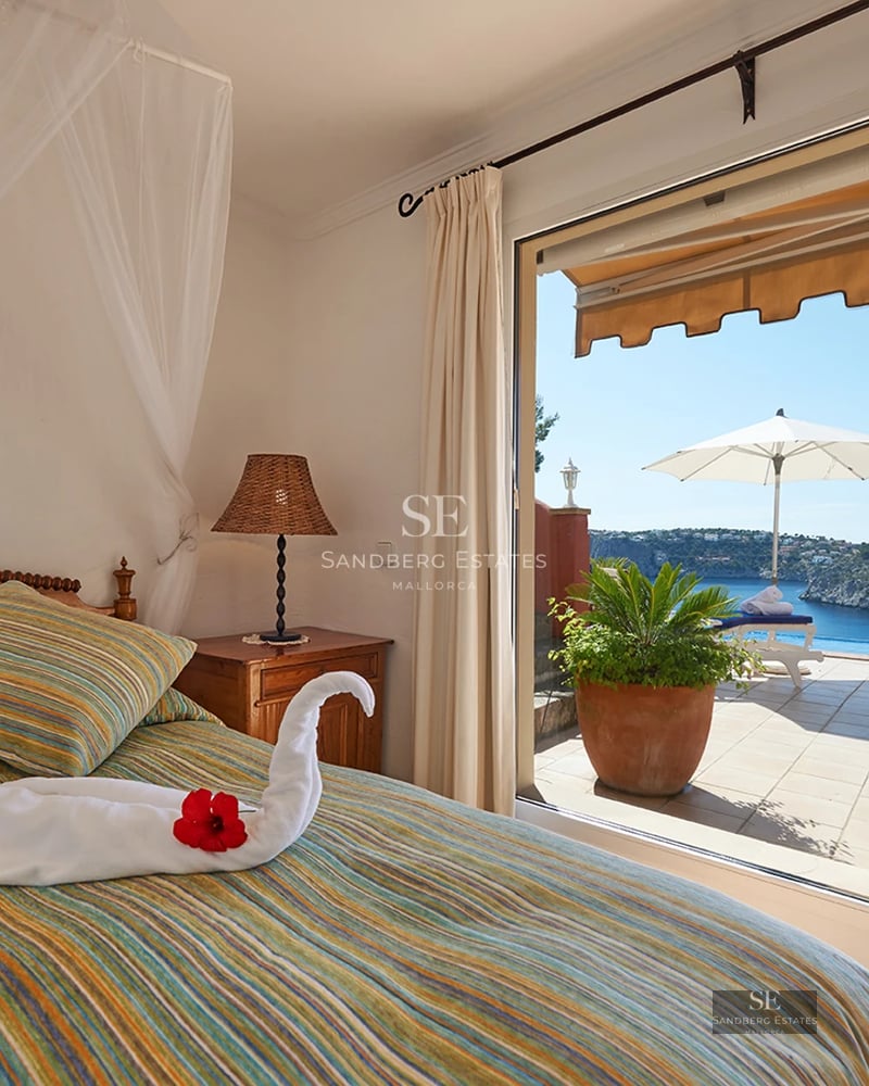Panoramic view from an elegant balcony with modern furniture and ocean view. Glass railing, wooden floor.