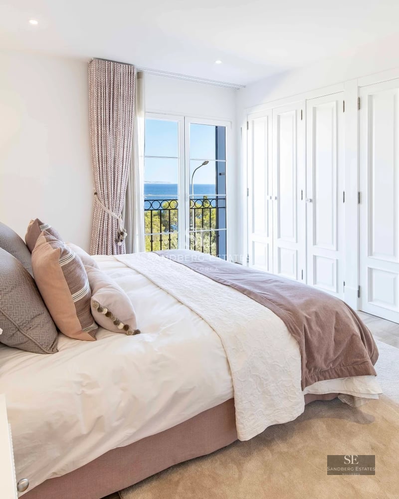 Spacious living room with fireplace, panoramic windows, and terrace access. Modern furnishings and elegant decor. Warm lighting.