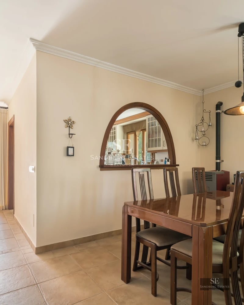 Spacious living room with picture windows, fireplace, leather sofas, and wood floors. Abundant natural light. Modern and elegant decor.