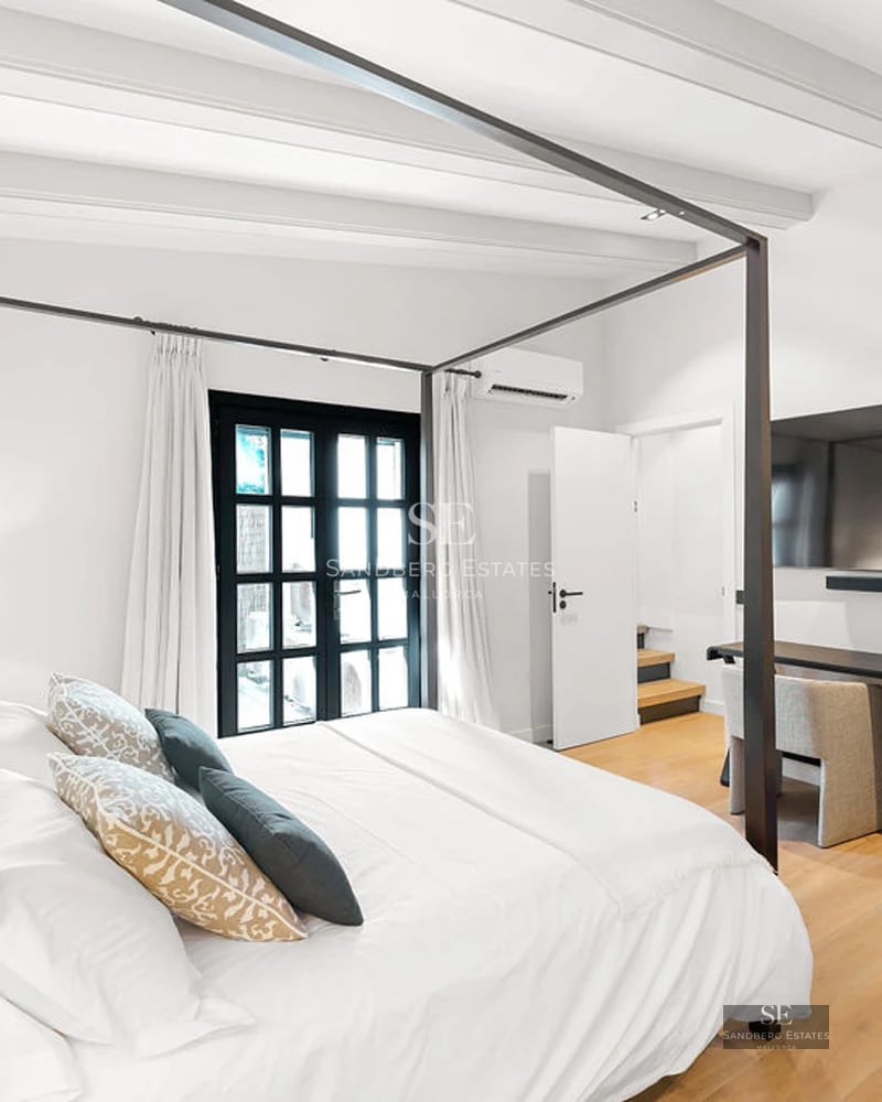 Spacious living room with picture windows, beige sofas, light wood coffee table, and modern decorative details. Natural lighting.