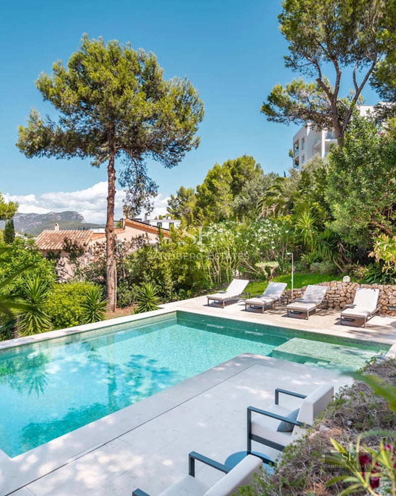 Spacious exterior with infinity pool, sun loungers, garden area, and panoramic views. Modern architecture with large windows.