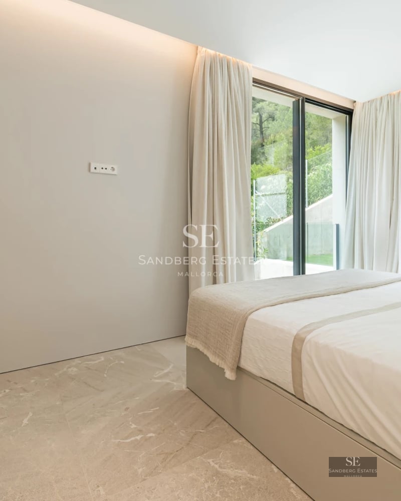 Spacious living room with fireplace and large windows. Designer sofas, soft rug, and panoramic views.