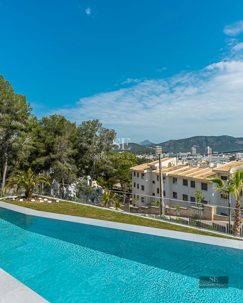 Spacious balcony with ocean view. Modern outdoor furniture, glass railings and wooden floors. Contemporary and elegant design.
