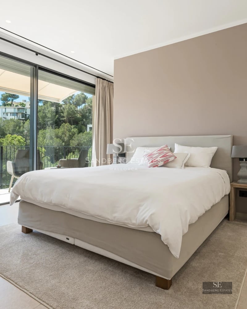 Spacious living room with floor-to-ceiling windows, modern fireplace, designer sofas, warm lighting, and access to a terrace with views.