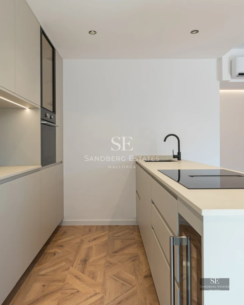 Bright living room with balcony, modern fireplace, light wood floors, and large windows offering panoramic views.