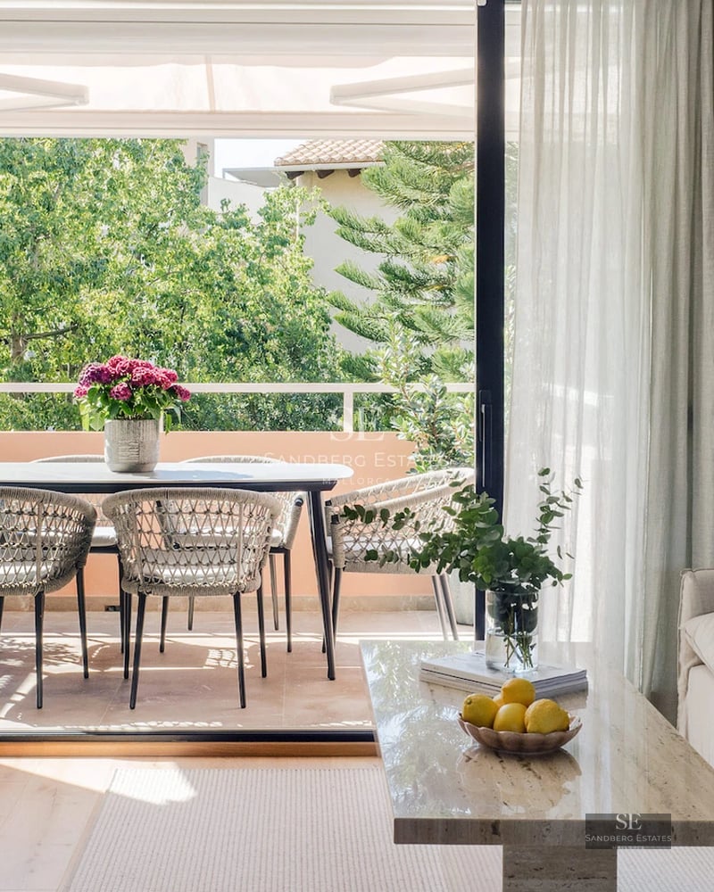 Exterior view of modern villa featuring an infinity pool, lush garden, and minimalist facade with large windows.