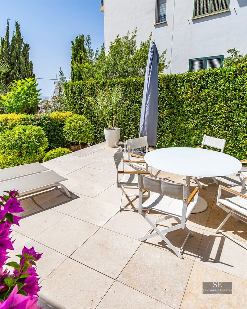 Exterior of a modern villa with a reflecting pool, surrounded by greenery. Minimalist design, large windows, and sleek terrace.