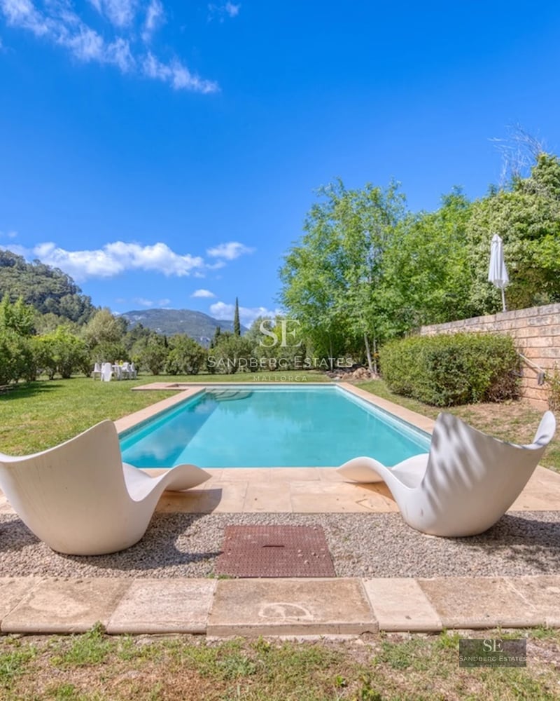 Spacious living room with picture windows, modern fireplace, and designer furniture. Panoramic views. Minimalist decor in neutral tones.