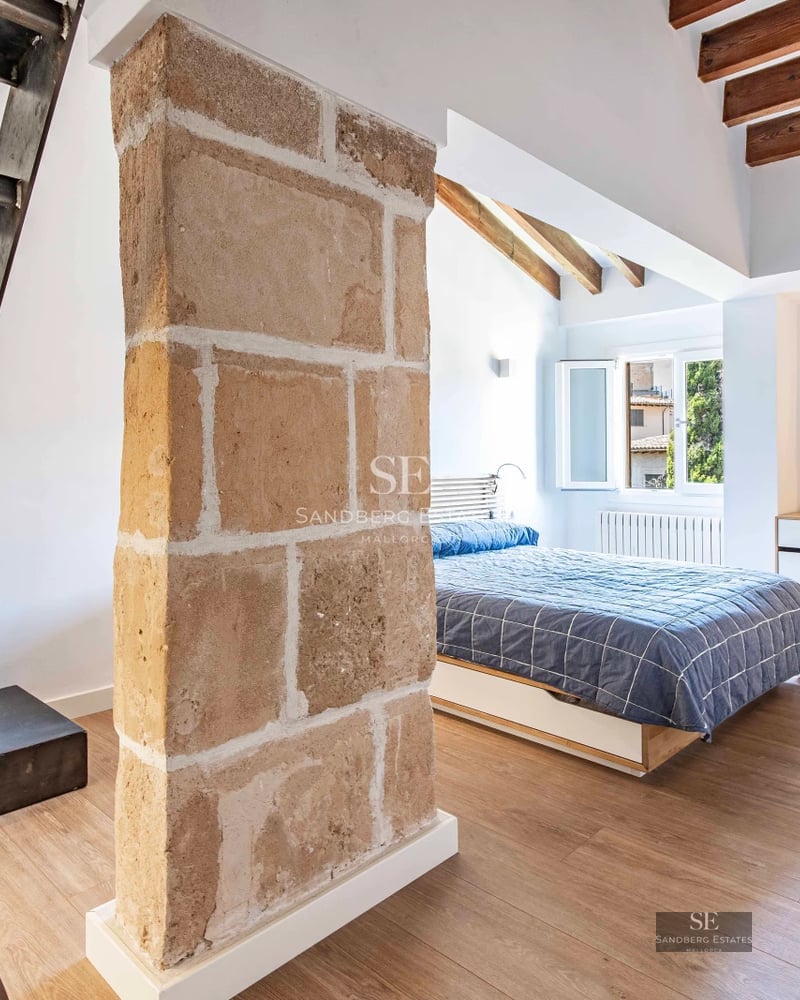 View of infinity pool with vanishing edge, surrounded by greenery and lounge chairs. Modern architecture with large windows and natural light.