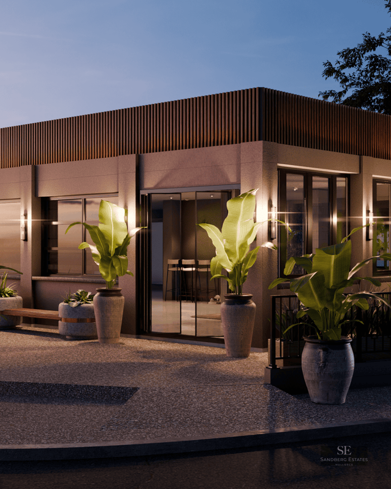 Modern building exterior at dusk with warm wall lighting, large potted plants, and sleek glass windows.