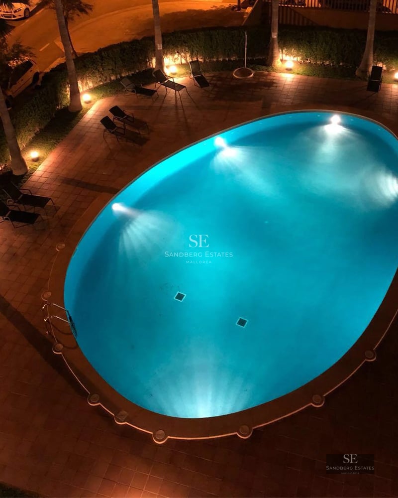 Vue d'une villa moderne avec piscine à débordement, mobilier extérieur élégant et vues panoramiques. Design minimaliste, vastes terrasses.