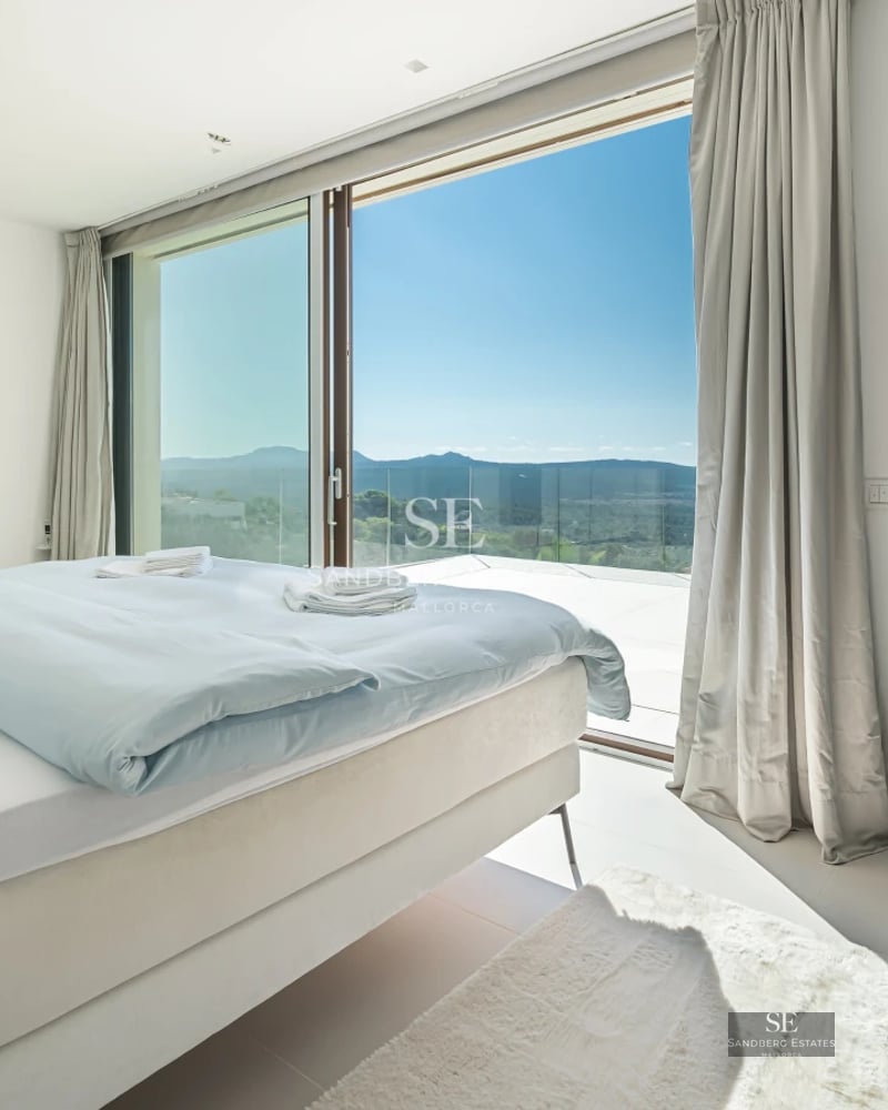 Exterior view of a modern villa with infinity pool, large windows, and minimalist architecture. Lush garden and clear sky.