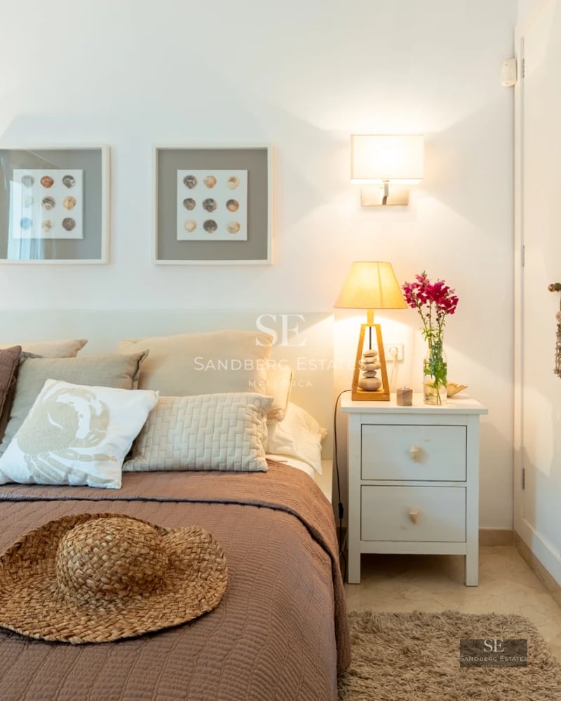 View of a luxurious pool with lounge chairs and lush vegetation. Modern architecture with large windows and minimalist design.