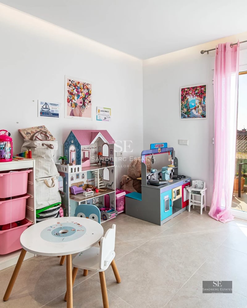 Spacious living room with floor-to-ceiling windows, balcony with sea view, light wood floors and modern design. Minimalist furniture and natural light.