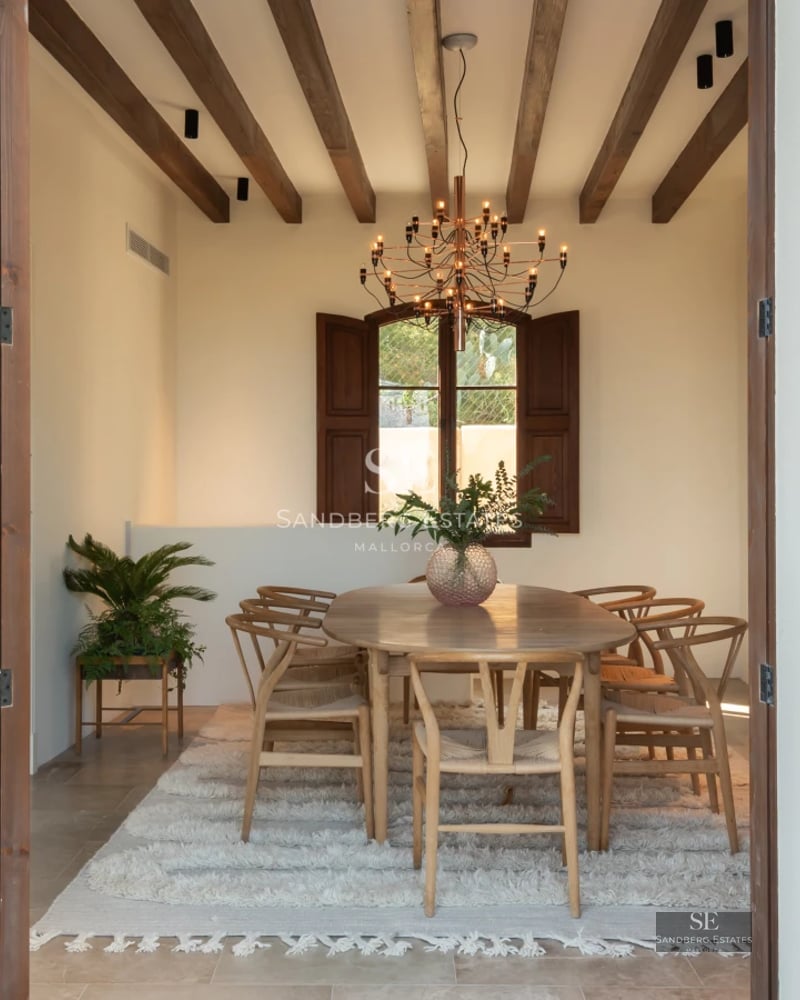 Pool view with modern design, stone edge, lounge chairs, and lush greenery. Natural lighting and blue skies.