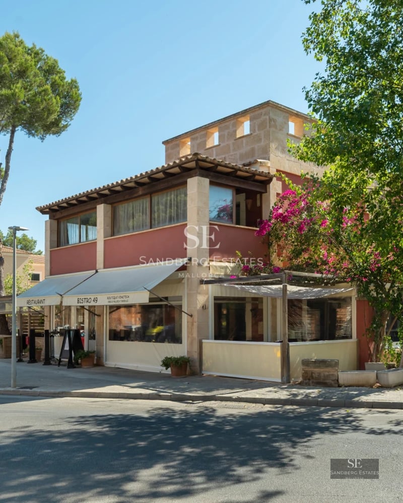 Spacious living room with floor-to-ceiling windows, natural light, light wood floors, and modern furniture. Garden and pool view.