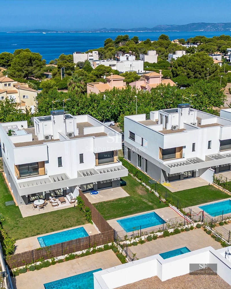 Exterior view of a modern villa with infinity pool, large windows, and lush landscaping. Sleek and contemporary design.
