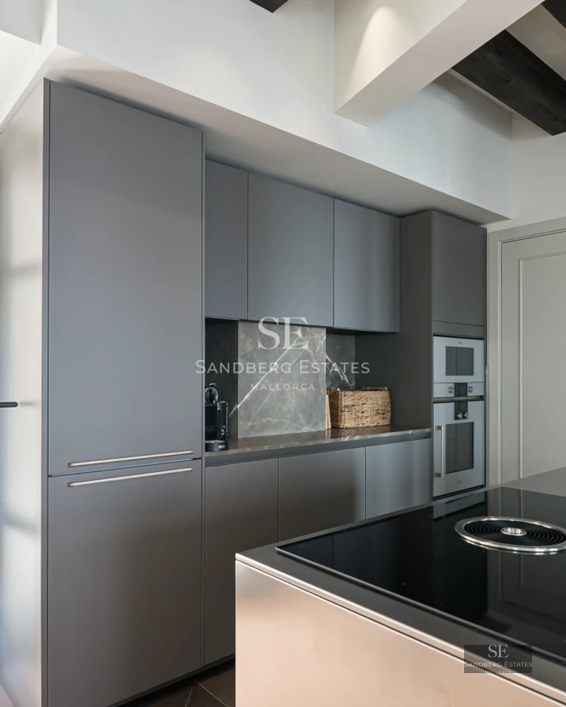 Exterior view of a modern villa with an infinity pool, large terraces, and minimalist design. Lush vegetation surrounds the property.