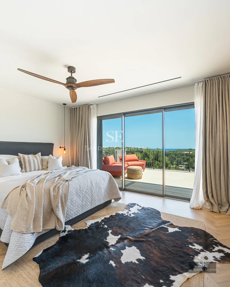 Extérieur d'une villa de luxe avec piscine, jardin et design architectural moderne. Larges baies vitrées et végétation luxuriante.