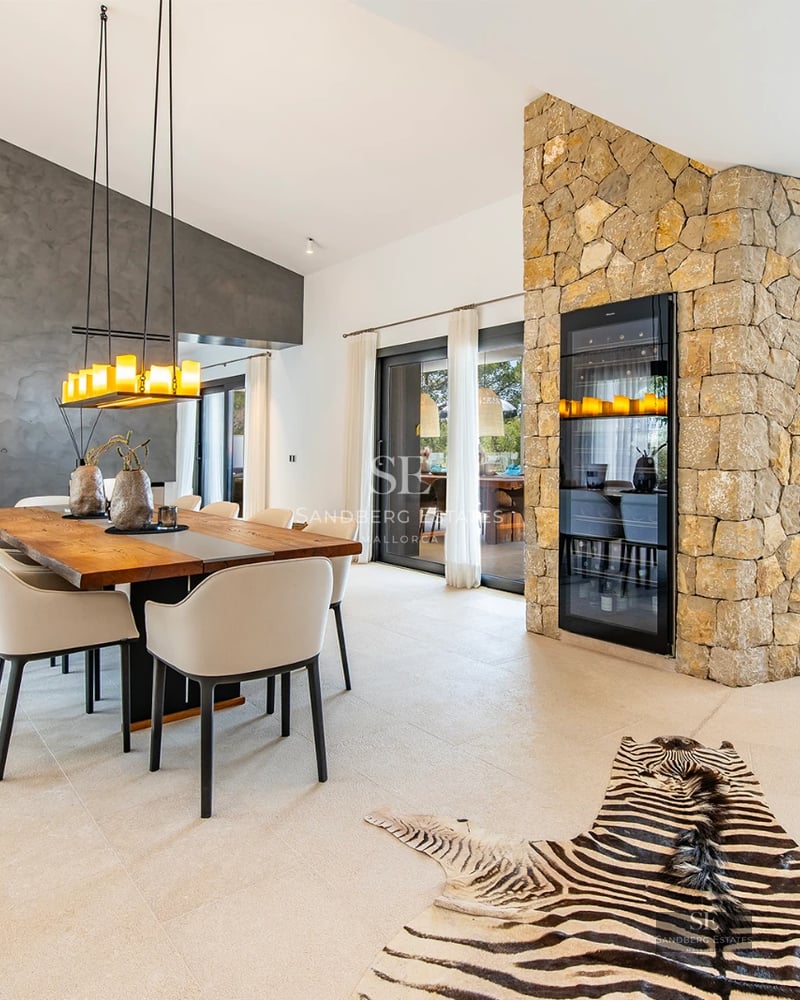 Exterior view of a modern villa with an infinity pool, large windows, and minimalist design. Manicured lawn and clear sky.