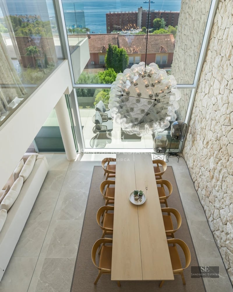 Exterior of modern villa featuring reflective pool, immaculate lawn, and minimalist architectural design.