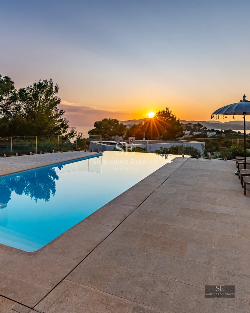 Exterior view of a modern house with a pool, well-kept garden, and large windows. Sleek and minimalist architectural design.
