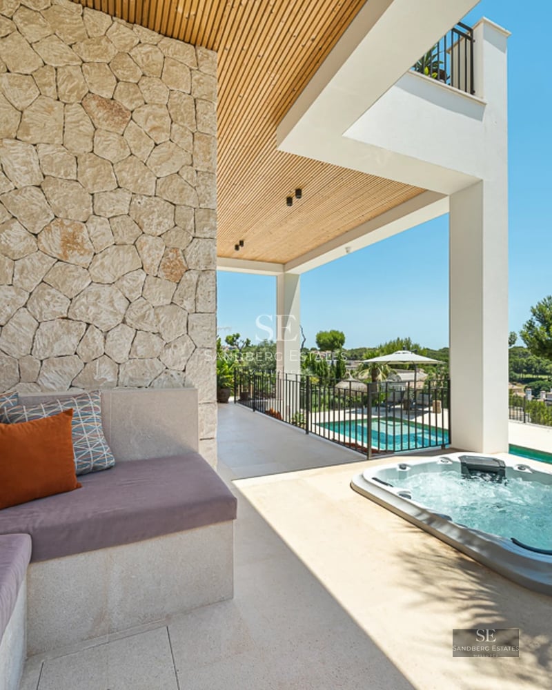 Terrasse avec piscine et vue panoramique sur la mer. Design moderne avec mobilier élégant et végétation luxuriante.