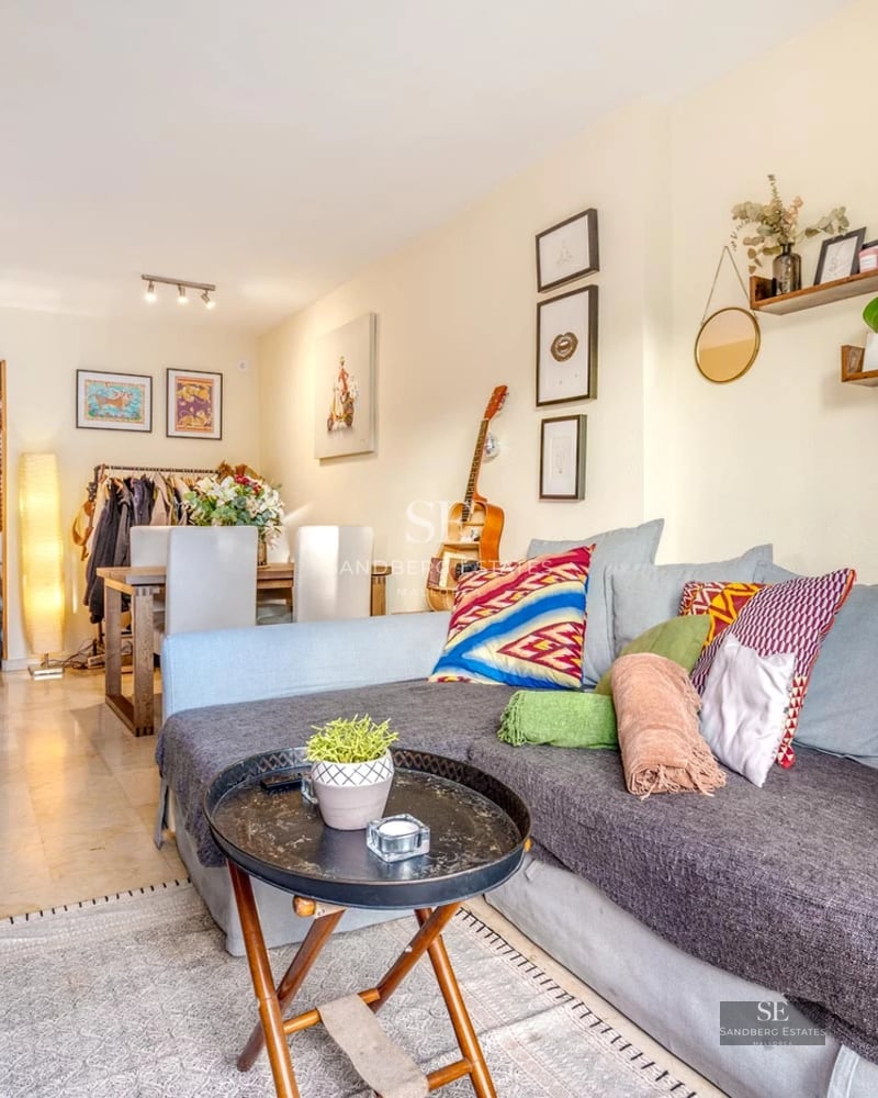 Salon lumineux avec grandes baies vitrées donnant sur piscine. Canapé modulable beige, tapis texturé et décoration minimaliste. Design moderne et élégant.