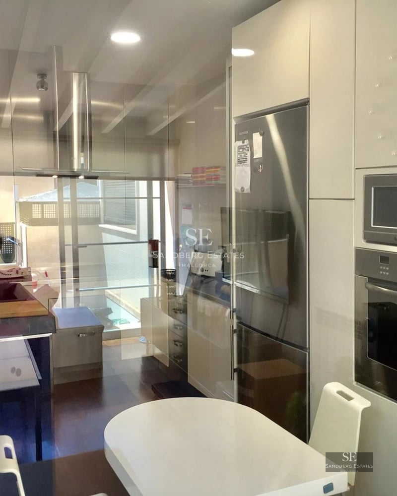 Spacious living room featuring panoramic windows, light wood floors, and a modern fireplace. Natural lighting and designer furniture.