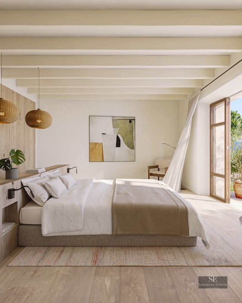 Master bedroom featuring light wood beams, neutral tones, and large open doors leading to a sunny terrace.