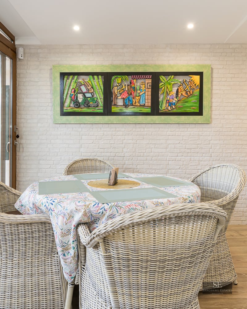 Dining area featuring wicker chairs, a white brick wall, and sliding glass doors.