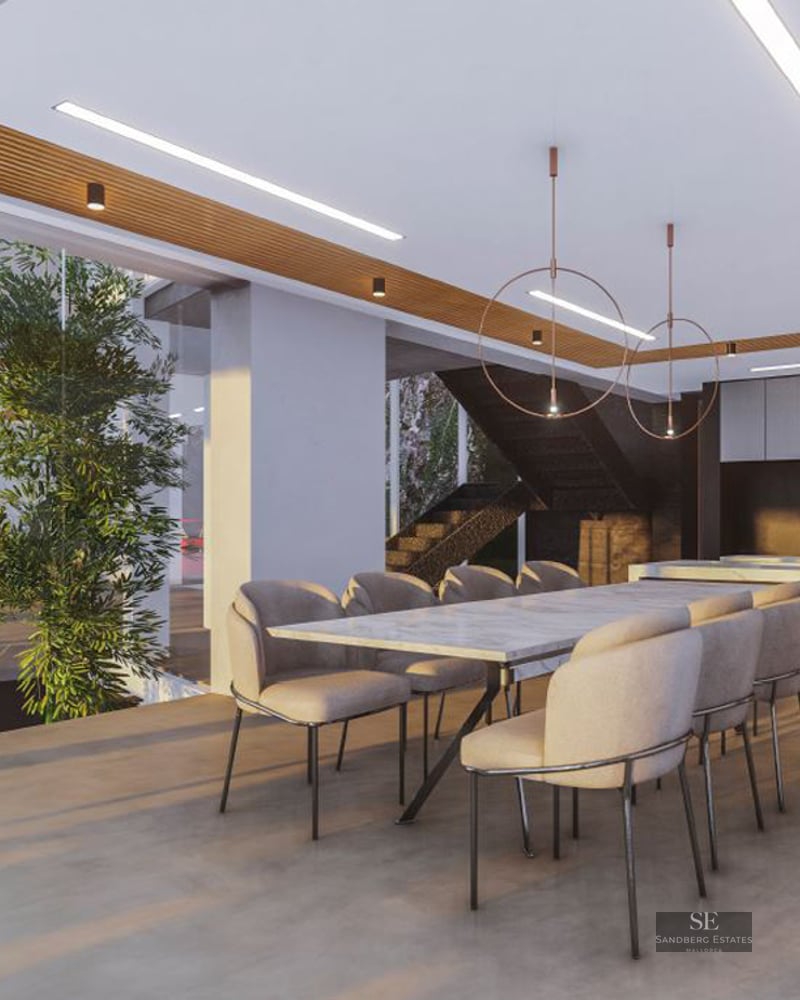 Elegant dining space featuring a marble table, beige velvet chairs, and an indoor tree beneath a slatted wood ceiling.