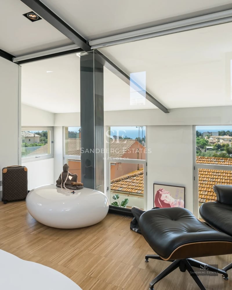 Exterior view of a modern villa featuring a pool, manicured garden, sleek design, and large windows maximizing natural light.