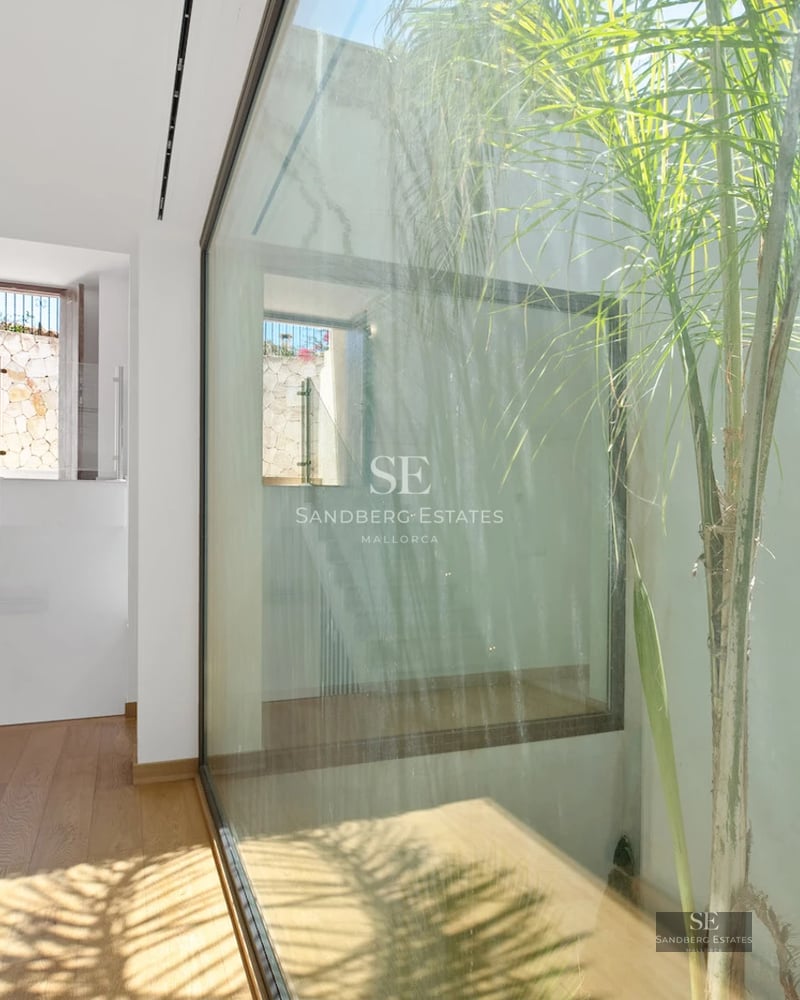 Exterior view of a modern luxury villa featuring a pool, lush garden, and large windows. Minimalist design with high-quality finishes.