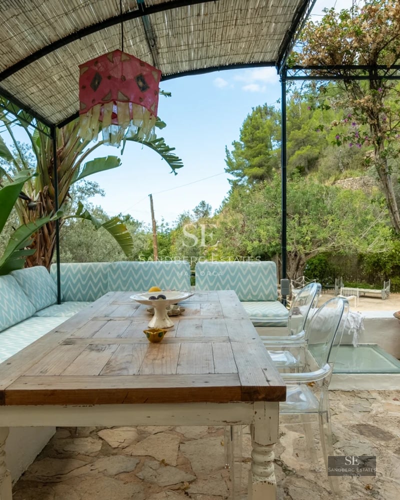 Exterior view of a luxurious modern villa with a pool, manicured garden, and large windows reflecting sunlight.