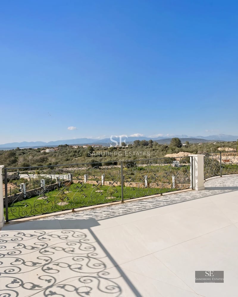 Spacious garden with a pool, sun loungers, and seating area. Modern architecture with large windows. Lush vegetation.