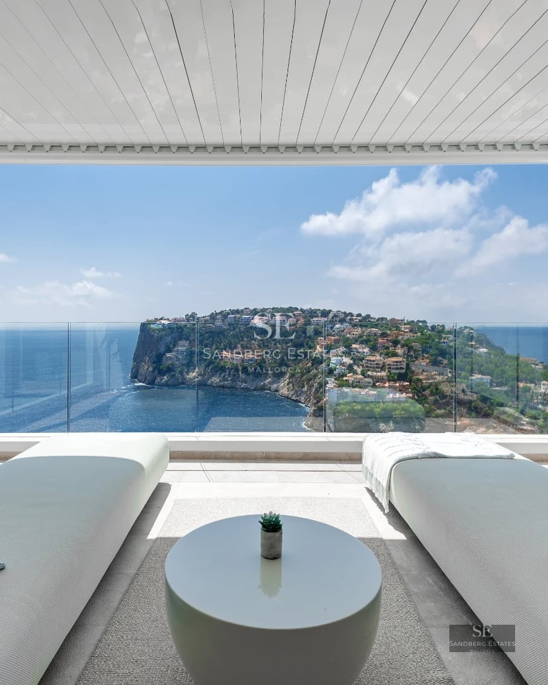 Infinity pool view. Modern architecture, large windows, manicured garden, clear blue sky. Natural lighting.