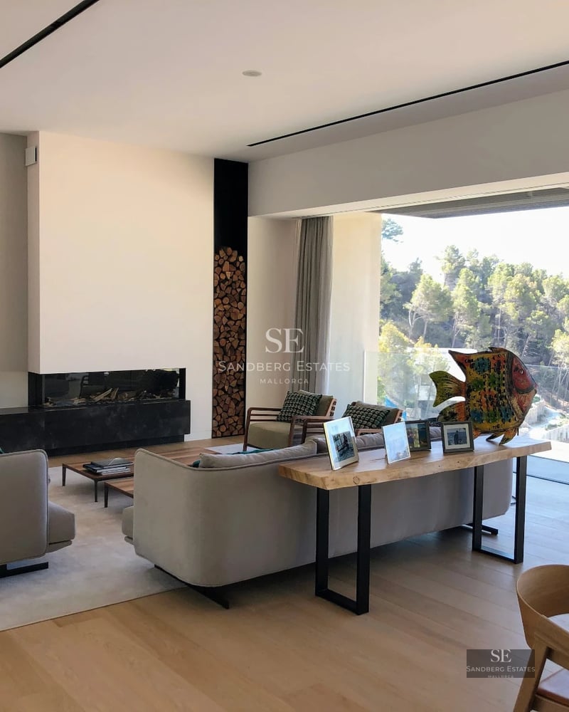 View of an infinity pool with sun loungers, umbrellas, and lawn. Modern and relaxing design with panoramic views.