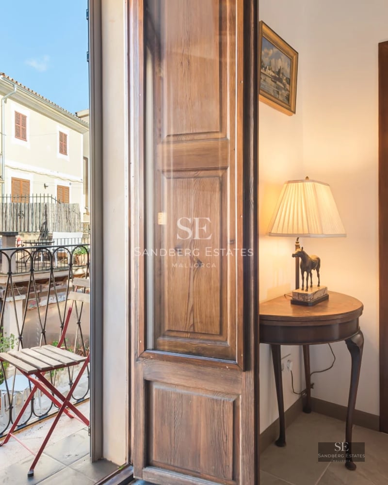 Pool view with light tiles, surrounded by greenery and stone walls. Natural lighting. Modern and elegant design.