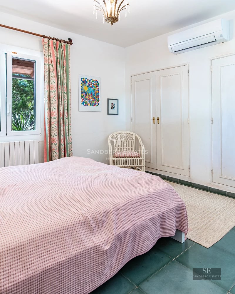 Exterior view of a modern villa featuring an infinity pool, expansive windows, elegant landscaping, and minimalist architecture.