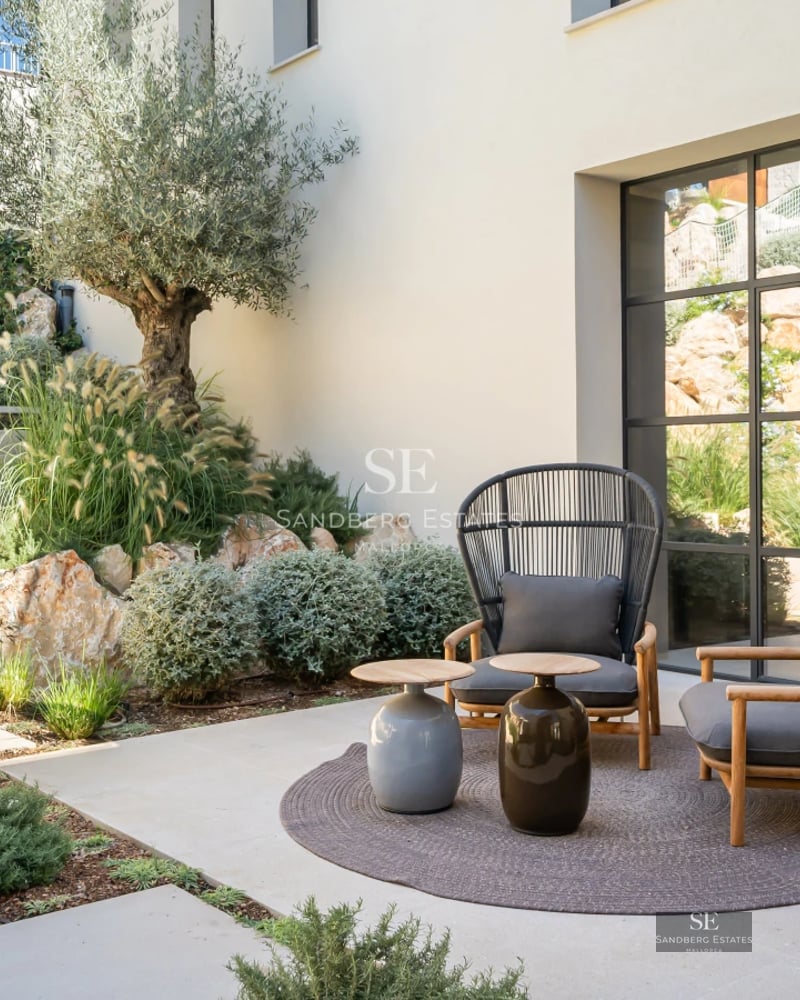 Spacious balcony with sea view, modern design, glass railing, and elegant outdoor furniture.