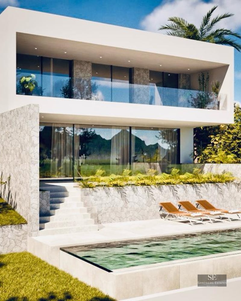 Modern white villa with an infinity pool, sun loungers, stone walls, and glass balconies under a blue sky.