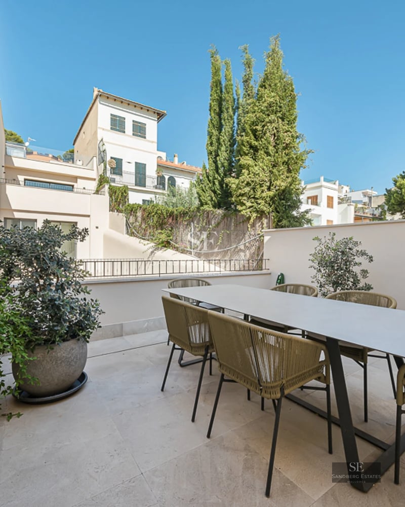 Spacious balcony with panoramic sea views. Light wood floors, glass railing, and modern furniture. Elegant and bright design.