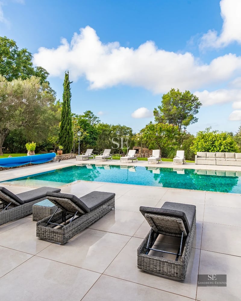 Spacious terrace with infinity pool. Panoramic views. Glass railing. Modern outdoor furniture. Ambient lighting.