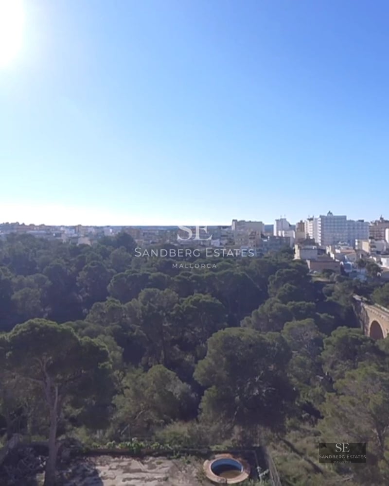 Spacious, bright living room with picture windows, light wood floors, modern furnishings, and direct access to the terrace with panoramic views.